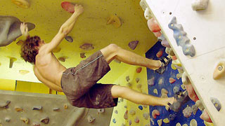 copyright: Jacqueline Kacetl a climber hanging head down from a climbing wall